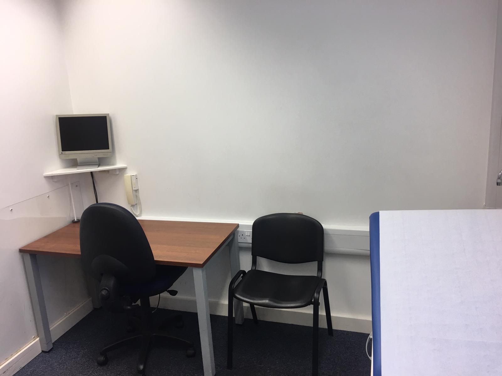 Consulting Room 1 with desk, chairs and clinical phone point